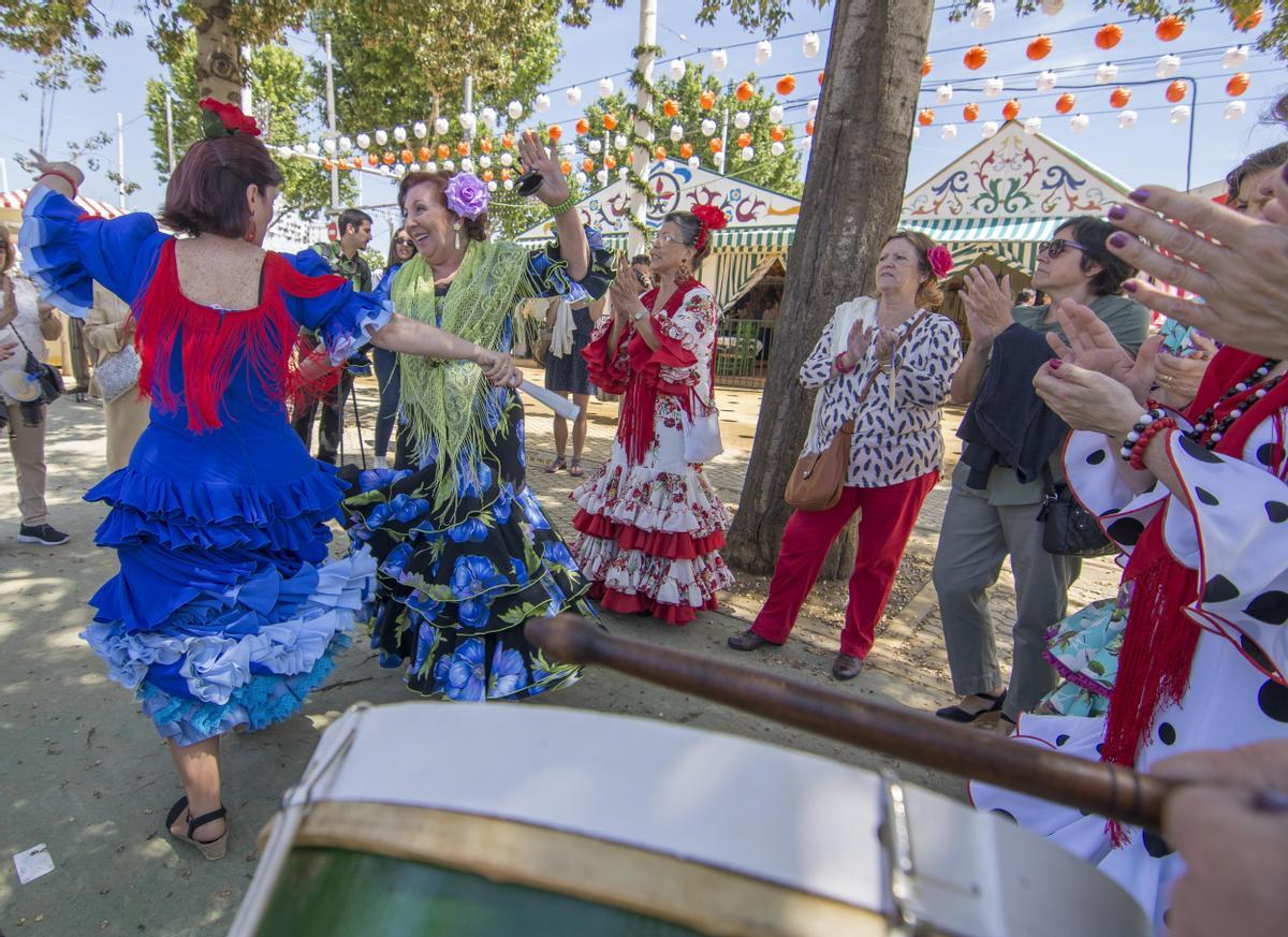 Un grupo de mujeres bailan en el Real de la Feria de Abril de Sevilla.