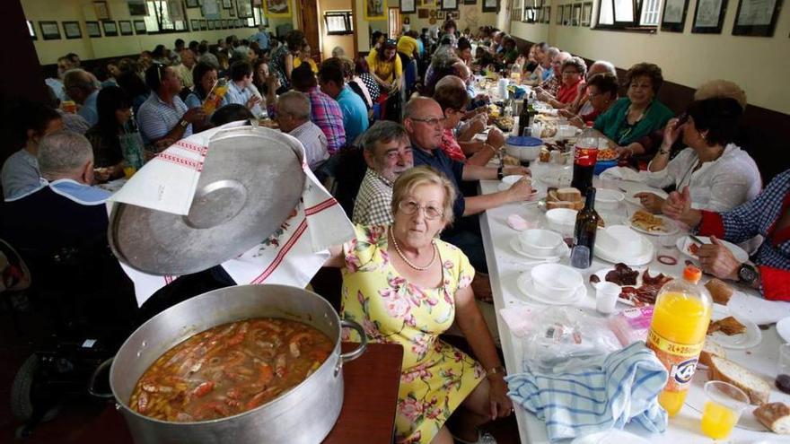 Vecinos durante la comida de hermandad de la fiesta de Santa Tecla celebrada el pasado septiembre en el centro social de Foxaco .