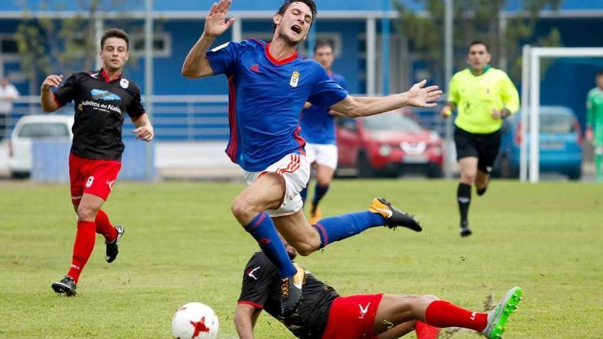 Borja Sánchez, interceptado por un jugador del Langreo, con César Suárez al fondo.