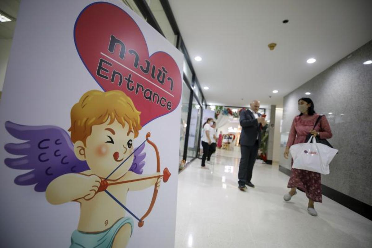 Una pareja casada se va después de una ceremonia de matrimonio masivo para celebrar el Día de San Valentín en una oficina de distrito en Bangkok, Tailandia