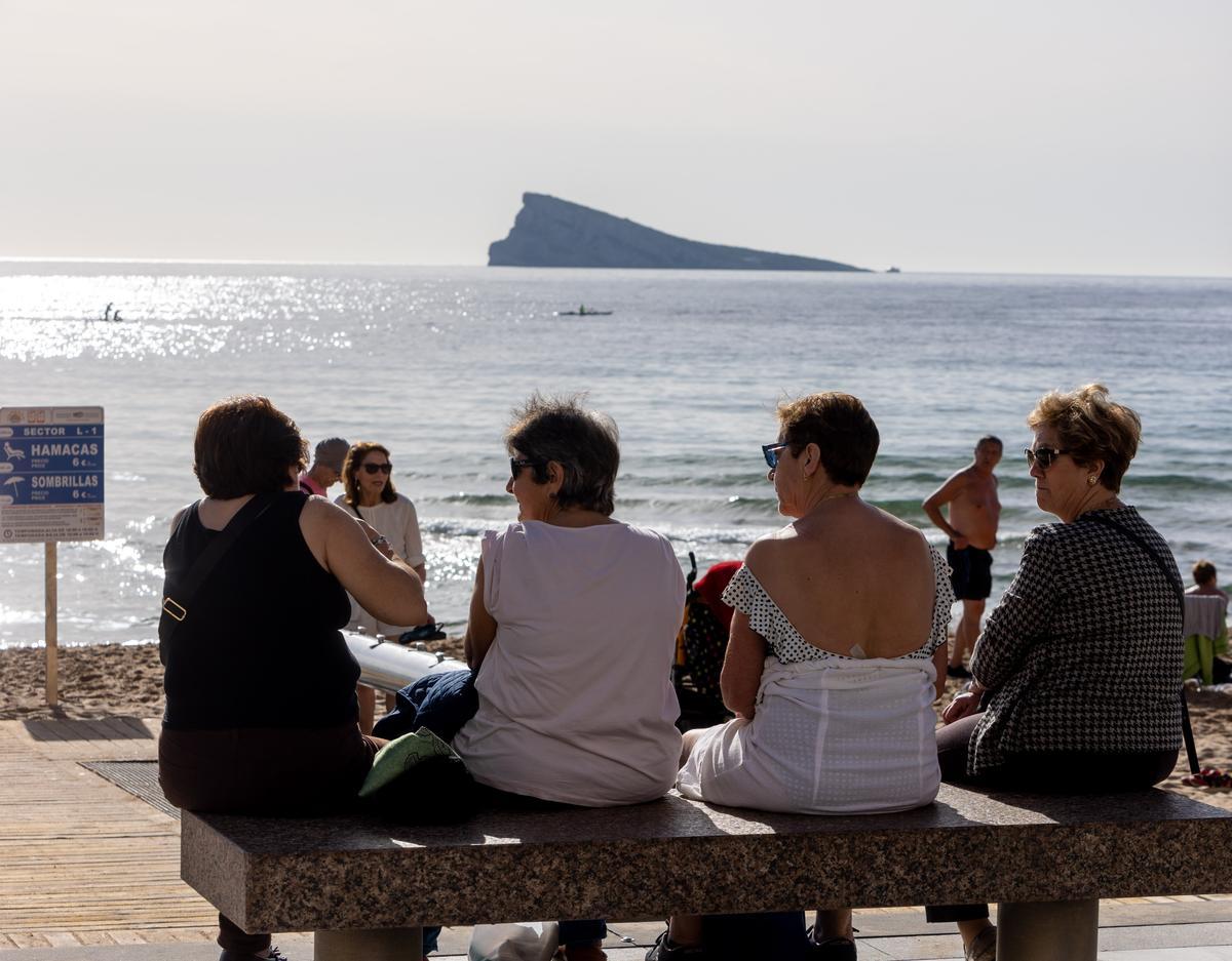 Varias mujeres charlan en un banco de la playa de Levante, aprovechando el buen tiempo de este invierno.