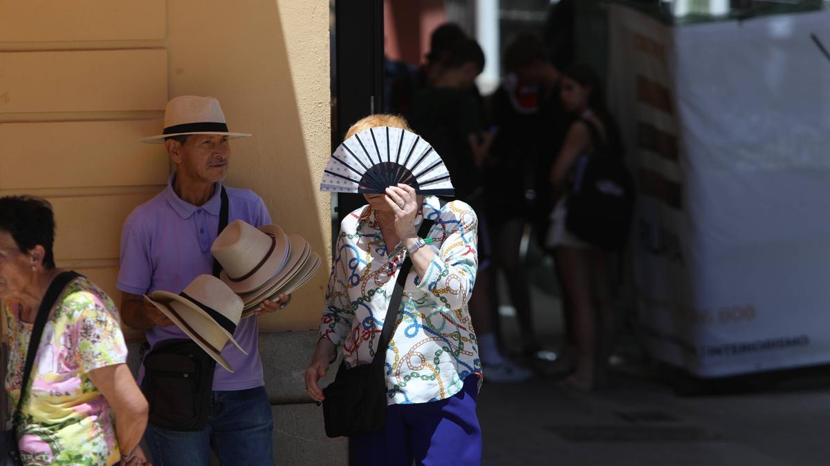 Personas en la calle se intentan proteger del calor intenso