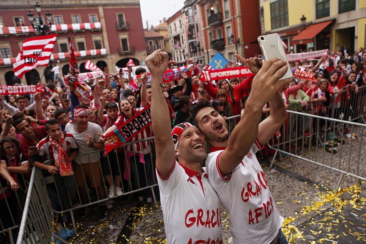Lora y Nacho Cases celebran el ascenso de los guajes en la Playa Mayor de Gijón.