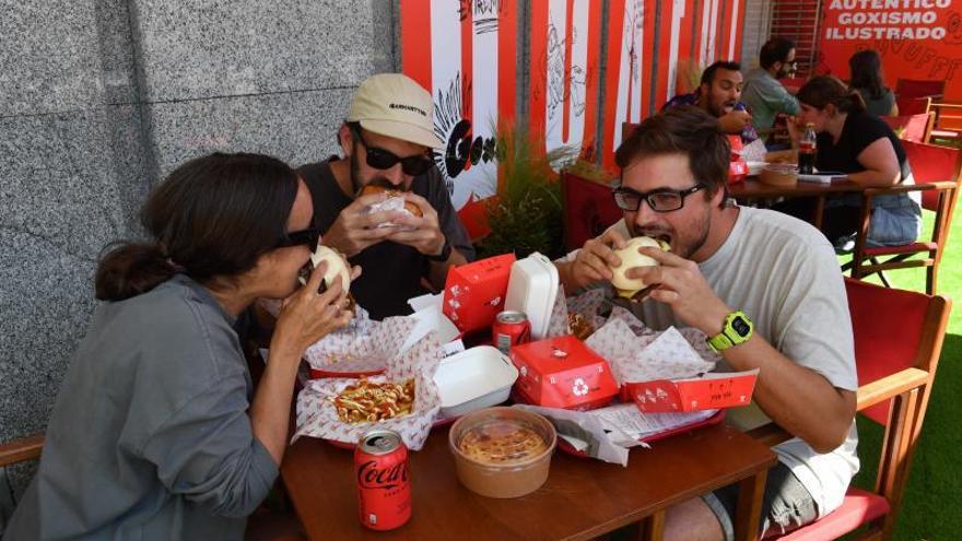 Los primeros clientes de GoXO, del cocinero Dabiz Muñoz, ayer, en la plaza de A Cubela, prueban sus recetas.   | // VÍCTOR ECHAVE