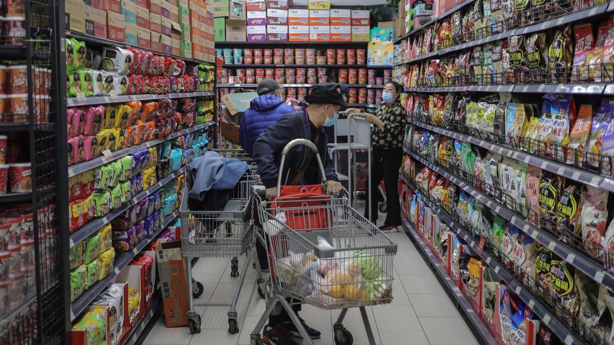 Varias personas realizan la compra en un supermercado en Pekín