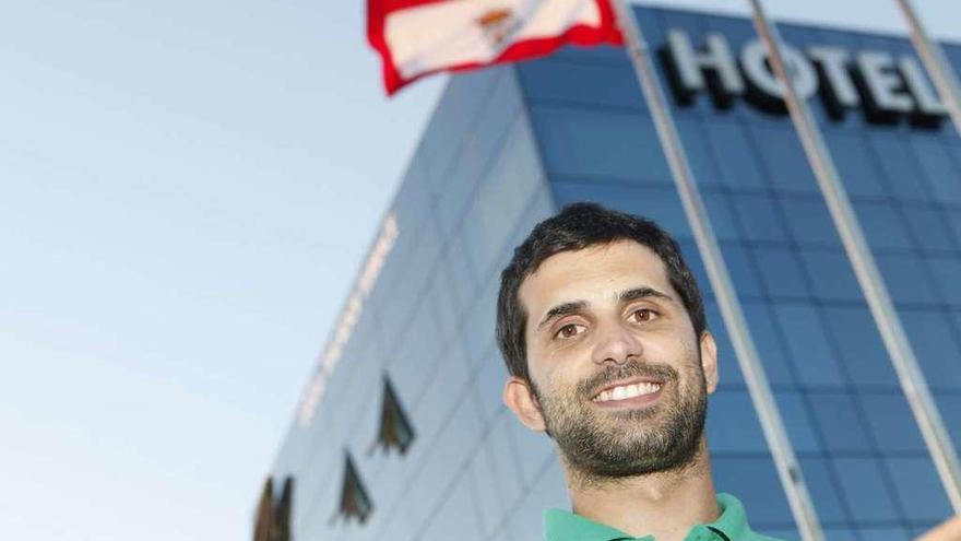 Álex López, bajo la bandera de Gijón, en el exterior de su hotel.