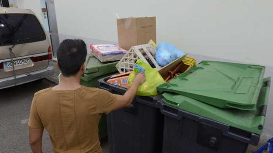 Un ciudadano deposita una bolsa de basura en un contenedor. | lp / dlp