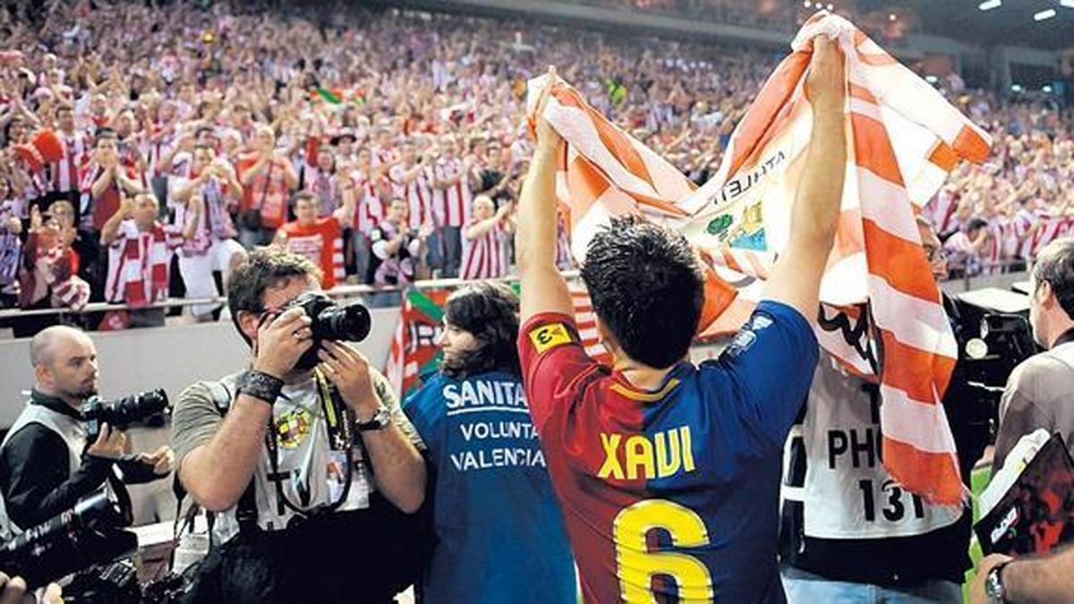 Xavi sostiene una bandera del Athletic tras ganar la Copa de 2009