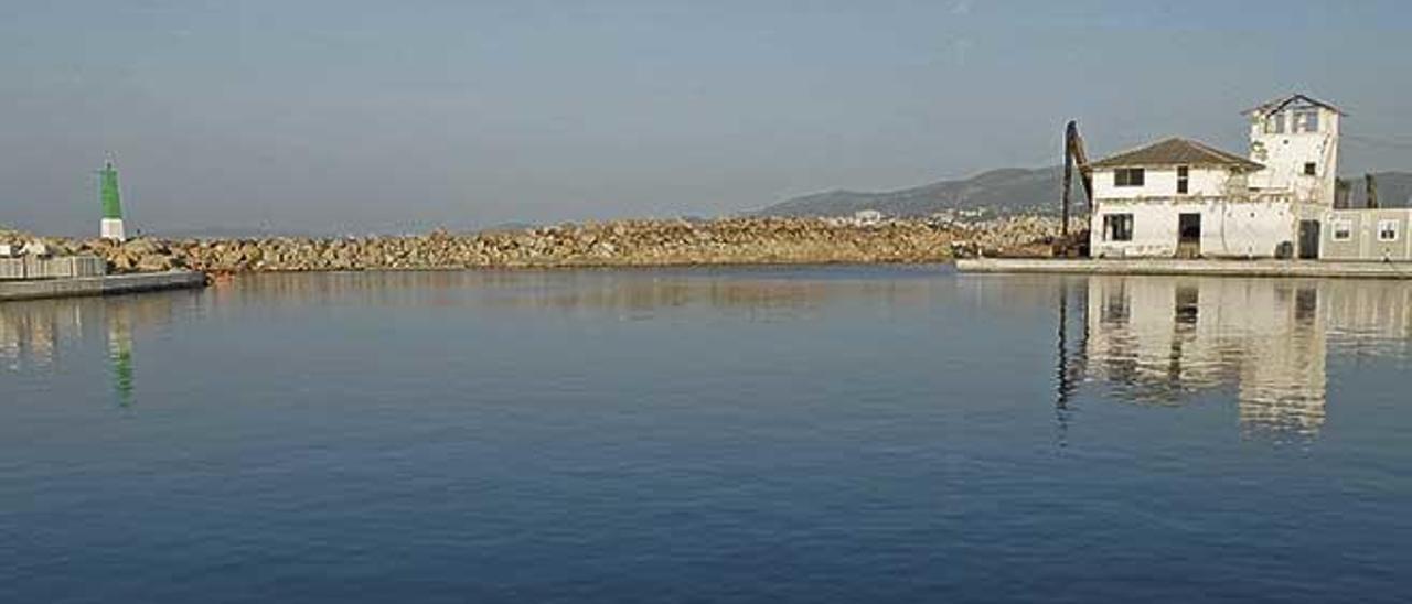 El espejo de agua del puerto del Molinar con el edificio protegido al fondo.