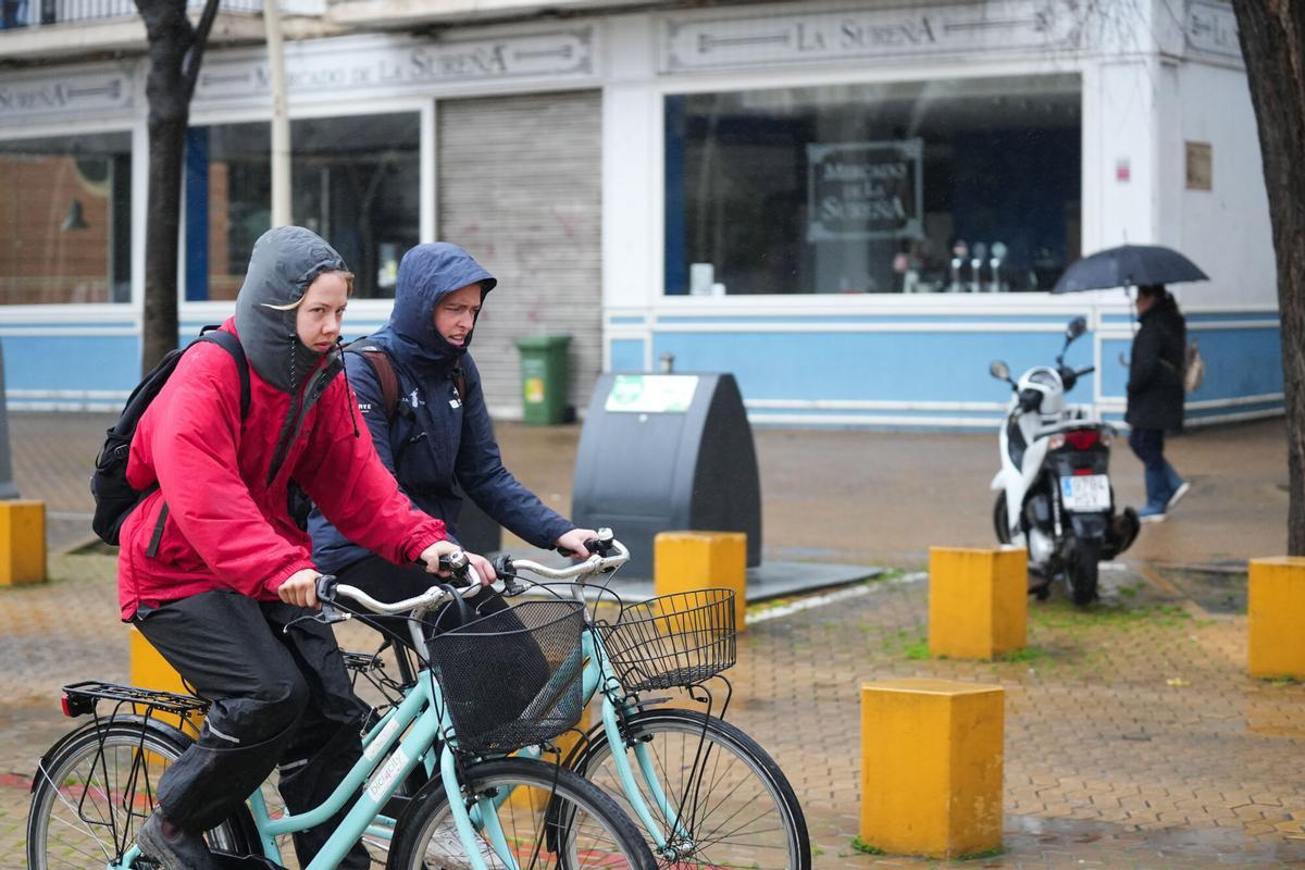 Transeúntes con paraguas en el centro de Sevilla durante el temporal de la borrasca Leonardo, que mantiene en alerta roja varios cauces de la provincia. Sevilla, España, 4 de febrero de 2026.