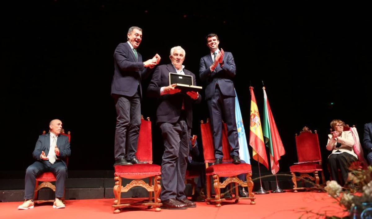 Rodríguez y Louzao, subidos a sillas para condecorar a Romay. | BERNABÉ/ AMANDA CASTRO