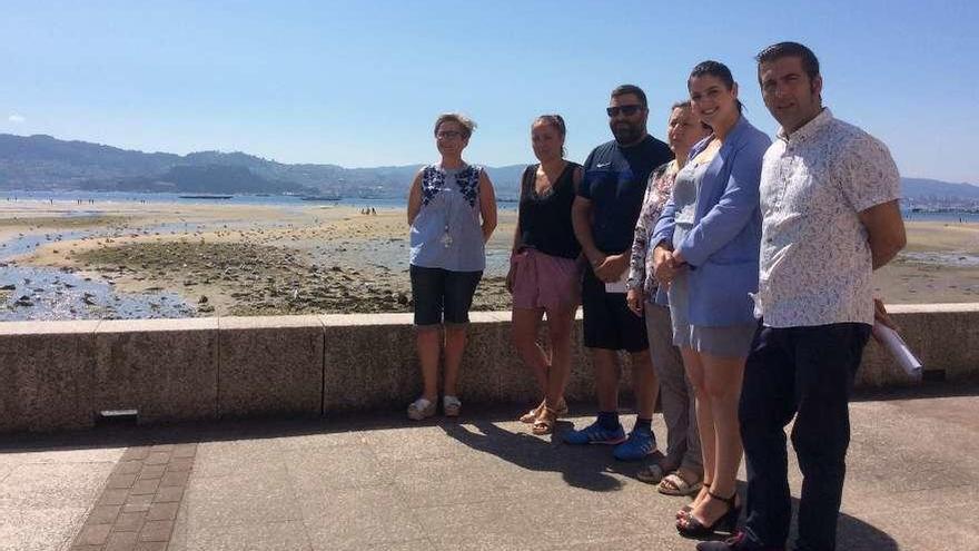 Desde la izquierda, las concejalas Coral Ríos y Marta Freire; el autor Xosé Daniel Currás; Marta Dacosta de la AELG; la alcaldesa Leticia Santos y el diputado Xosé Leal, con la ensenada de Moaña de fondo. //S.Á