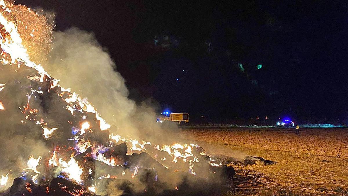 Los servicios de emergencia, junto a la montaña de pacas envuelta en llamas. | Bomberos Toro