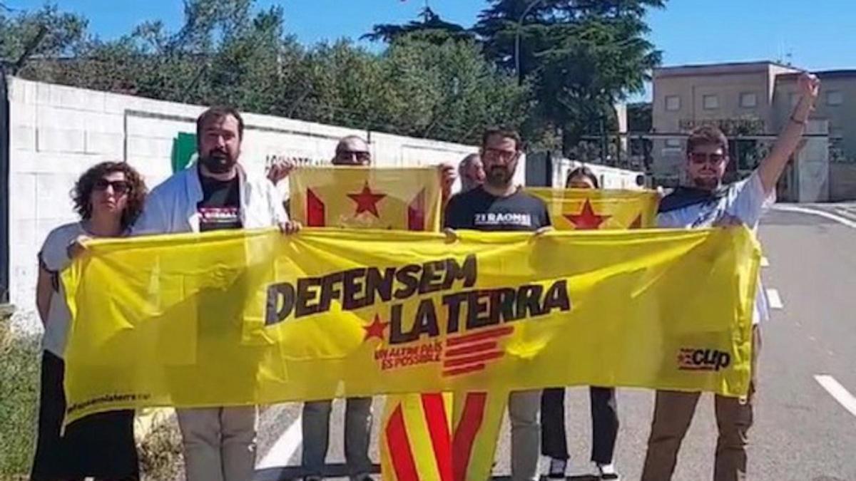 El diputat Dani Cornellà i membres de la CUP darrere una pancarta.