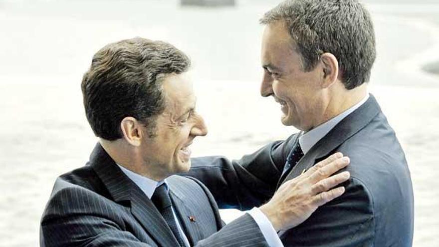 Sarkozy y Zapatero se abrazan en París, en julio pasado.