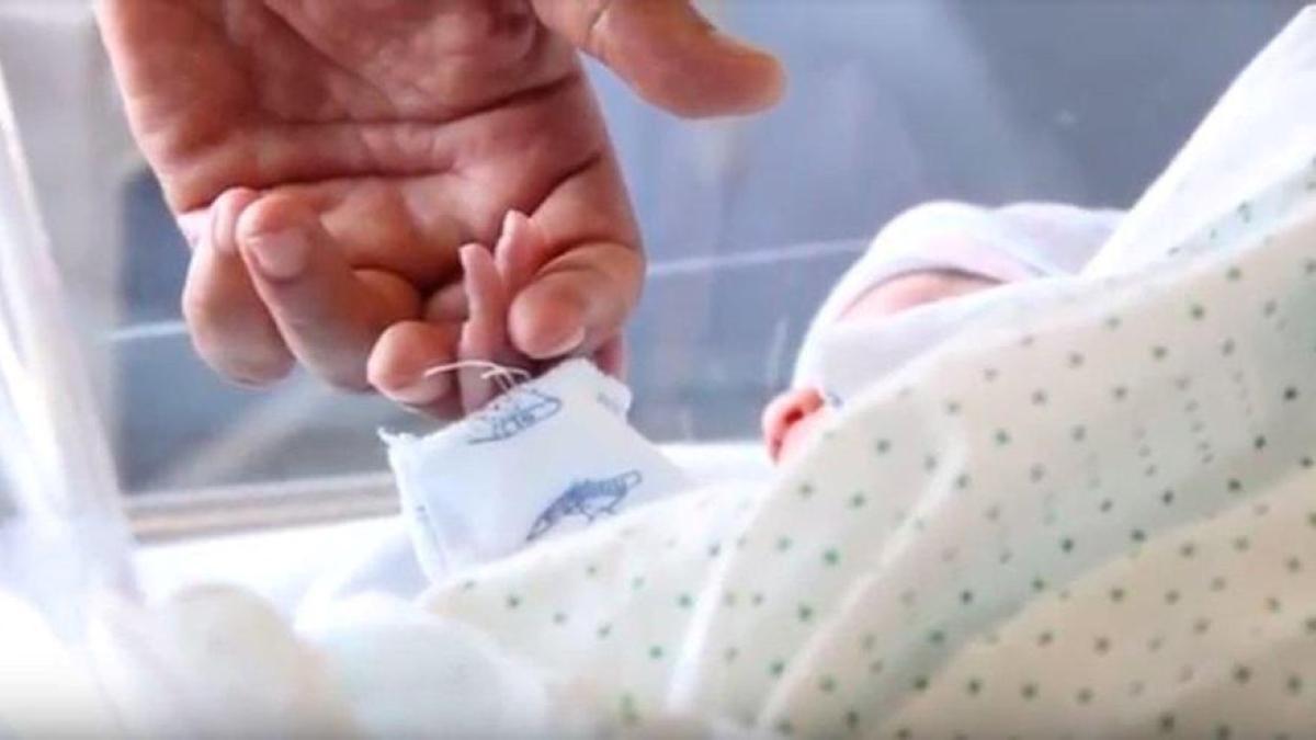 Imagen de archivo de una madre dándole la mano a su bebé