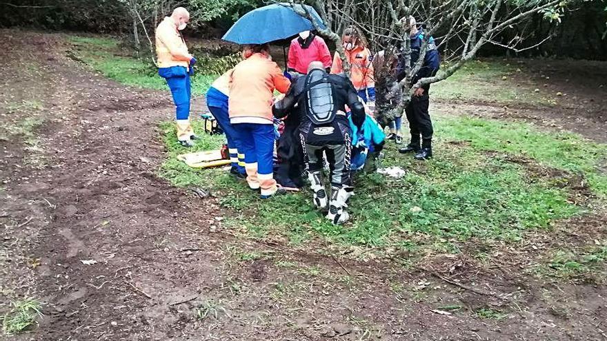 Técnicos de la ambulancia y agentes atienden al motorista.