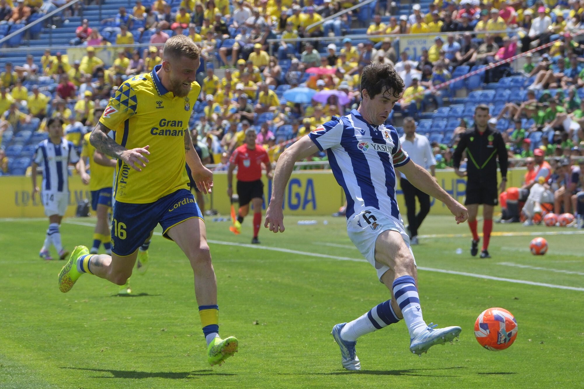 LAS PALMAS DE GRAN CANARIA, 06/04/2025.- El defensa de la Real Sociedad Aritz Elustondo (dcha) controla el balón ante el delantero escocés de la UD Las Palmas, Oliver McBurnie, durante el partido de LaLiga disputado este domingo en el estadio de Gran Canaria en Las Palmas. EFE/Ángel Medina G.