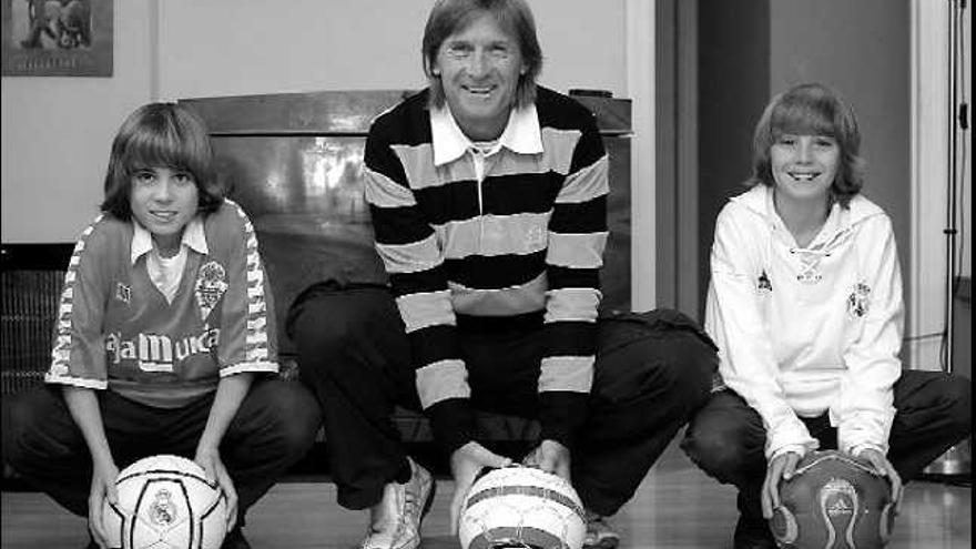 Ángel Pérez García posa junto a sus hijos Ángel, con la camiseta del Murcia, y Antonio, con la del Real Madrid, en su casa en Murcia