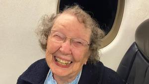 Patricia, sonriente a sus 101 años, en el interior de un avión.
