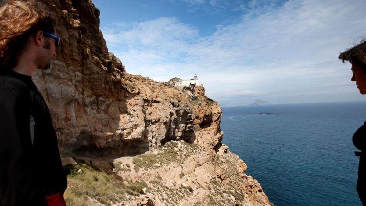 Senderistas con el Faro de Albir de fondo