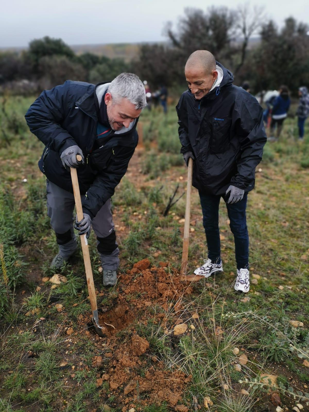 Dos internos haciendo un hoyo para plantar un árbol.