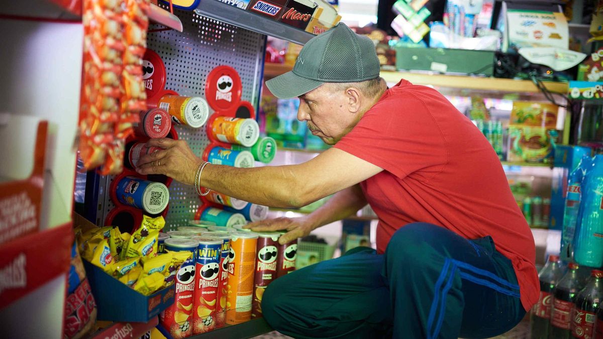 Un trabajador de un pequeño comercio de las Islas revisa la mercancía.