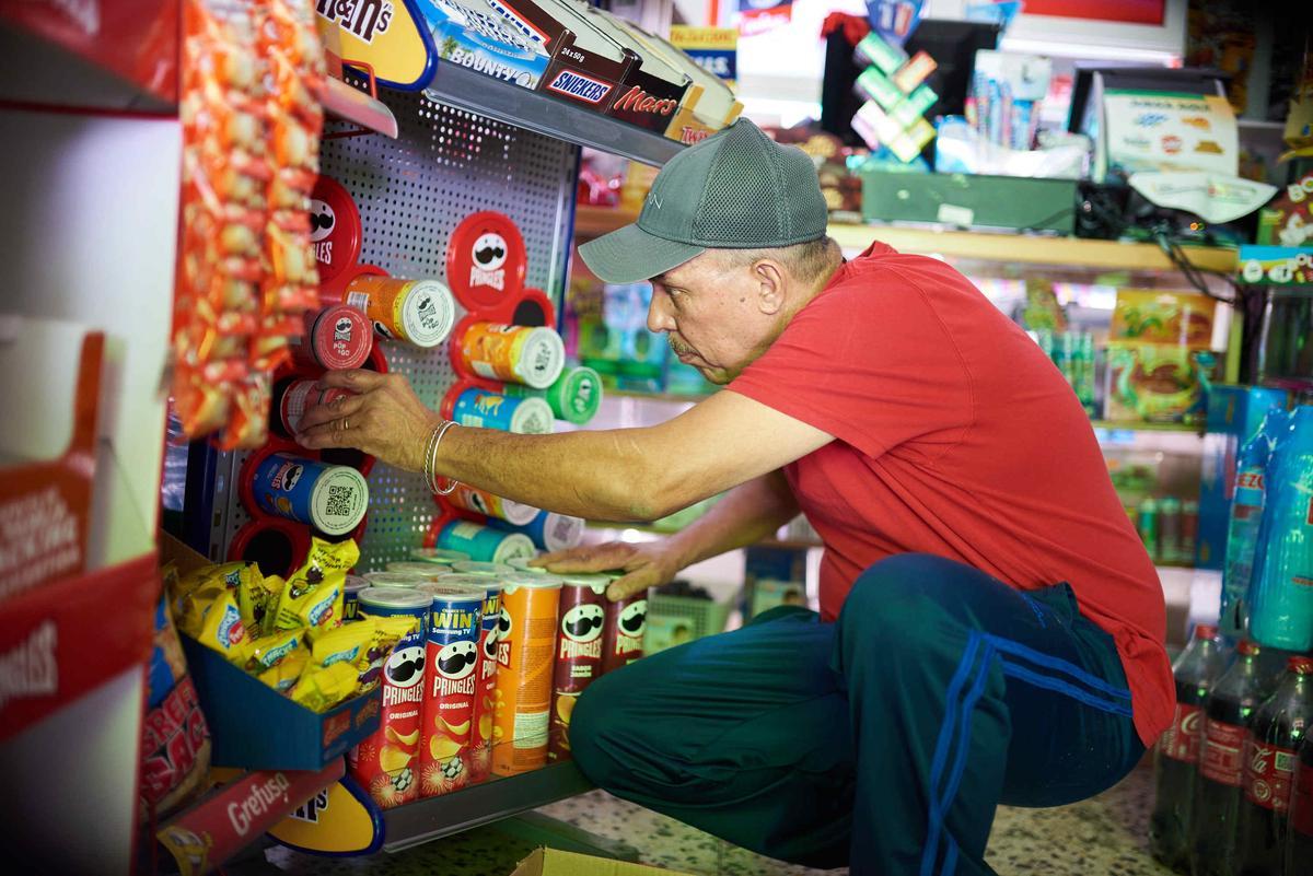 Un trabajador de un pequeño comercio de las Islas revisa la mercancía.