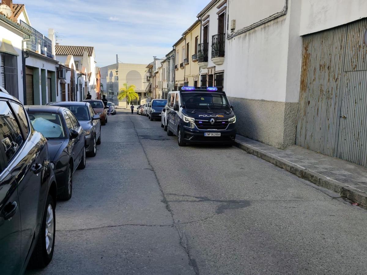 Un vehículo de la Policía Navioanl y varios agentes en una de las calles de Lucena.