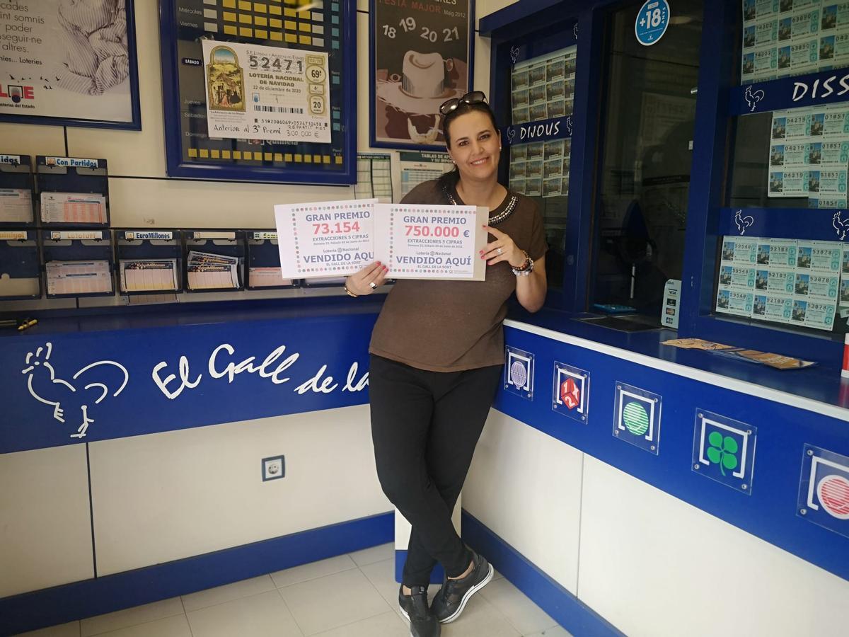 Anna Ballester, propietària d’El Gall de la Sort de Porqueres, mostrant el número guanyador i el premi.