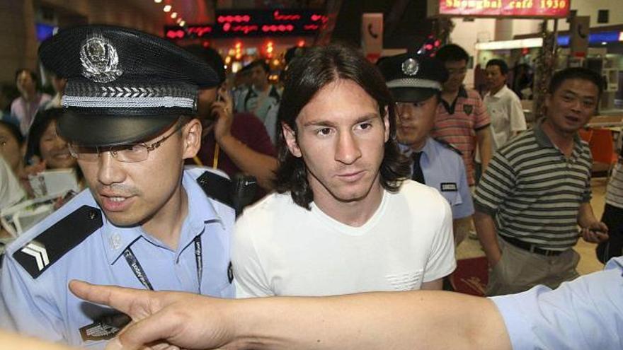 - El delantero blaugrana Lionel Messi, escoltado por la policía y miembros del Comité Organizador de los Juegos Olímpicos de Pekín 2008 , a su llegada hoy al aeropuerto de Shanghai para sumarse a la selección olímpica de su país.