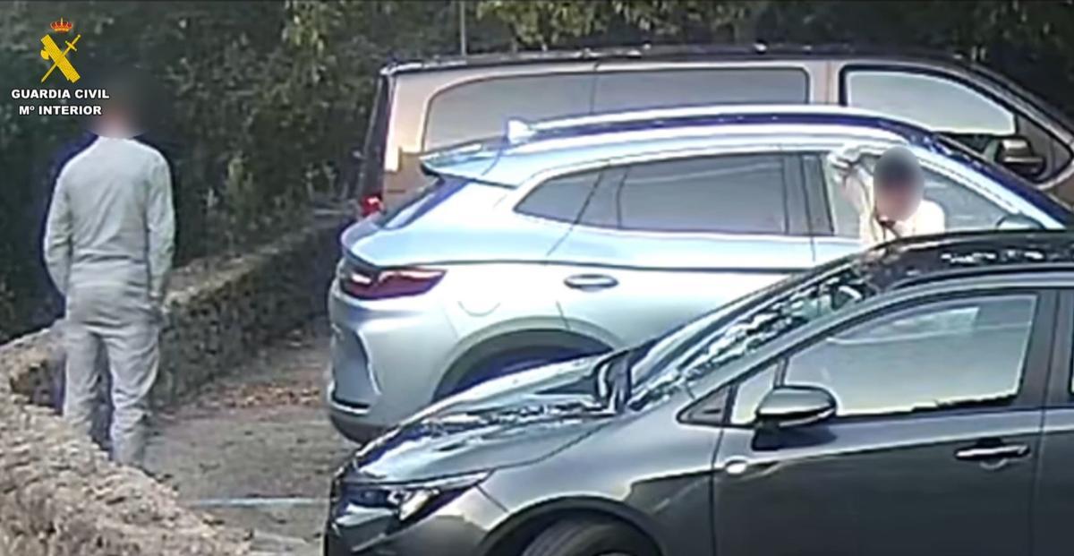 Dos presuntos ladrones durante el robo en uno de los coches aparcados en sa Calobra.