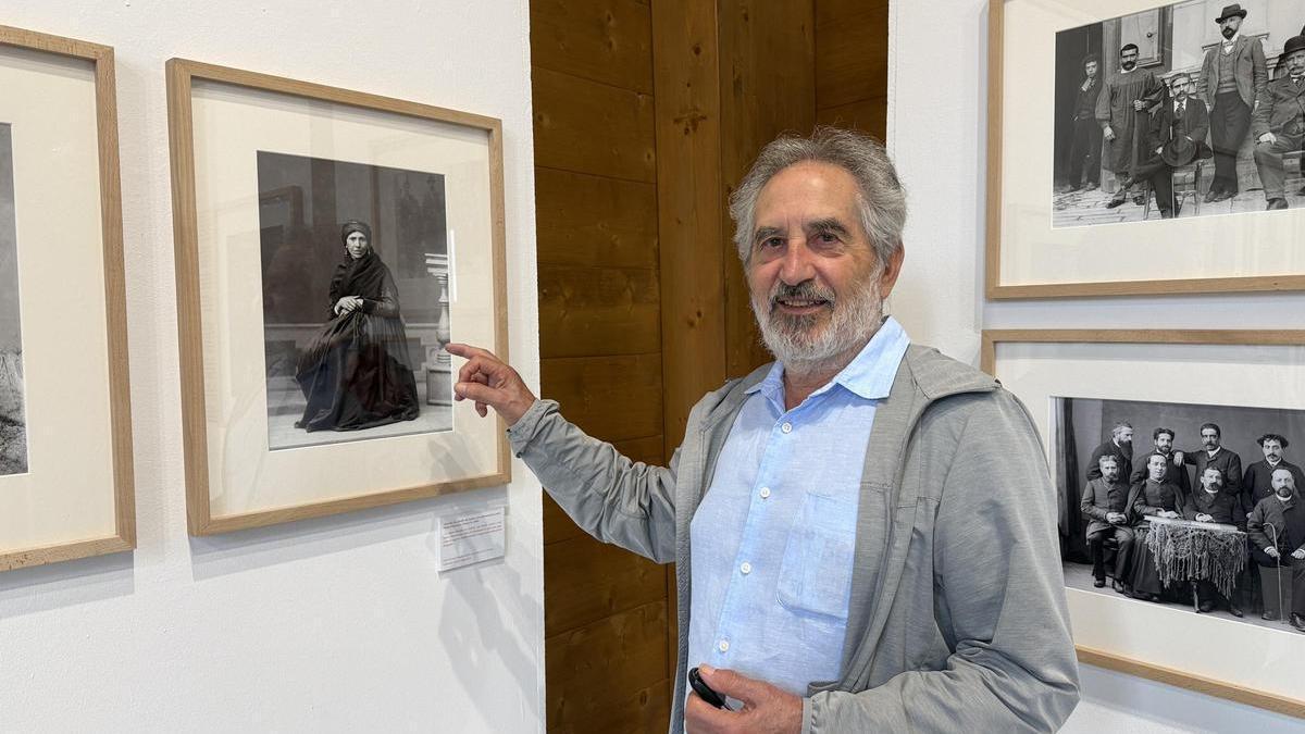 Antonio Diego Llaca, comisario de la muestra, junto a una de las fotografías expuestas.