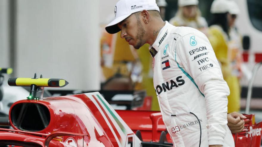 Lewis Hamilton observa el monoplaza de Ferrari