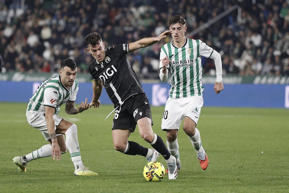 Curro Sánchez, jugador del Burgos CF, en el partido de ida ante el Córdoba CF, defendido por Requena y Álex Martín.