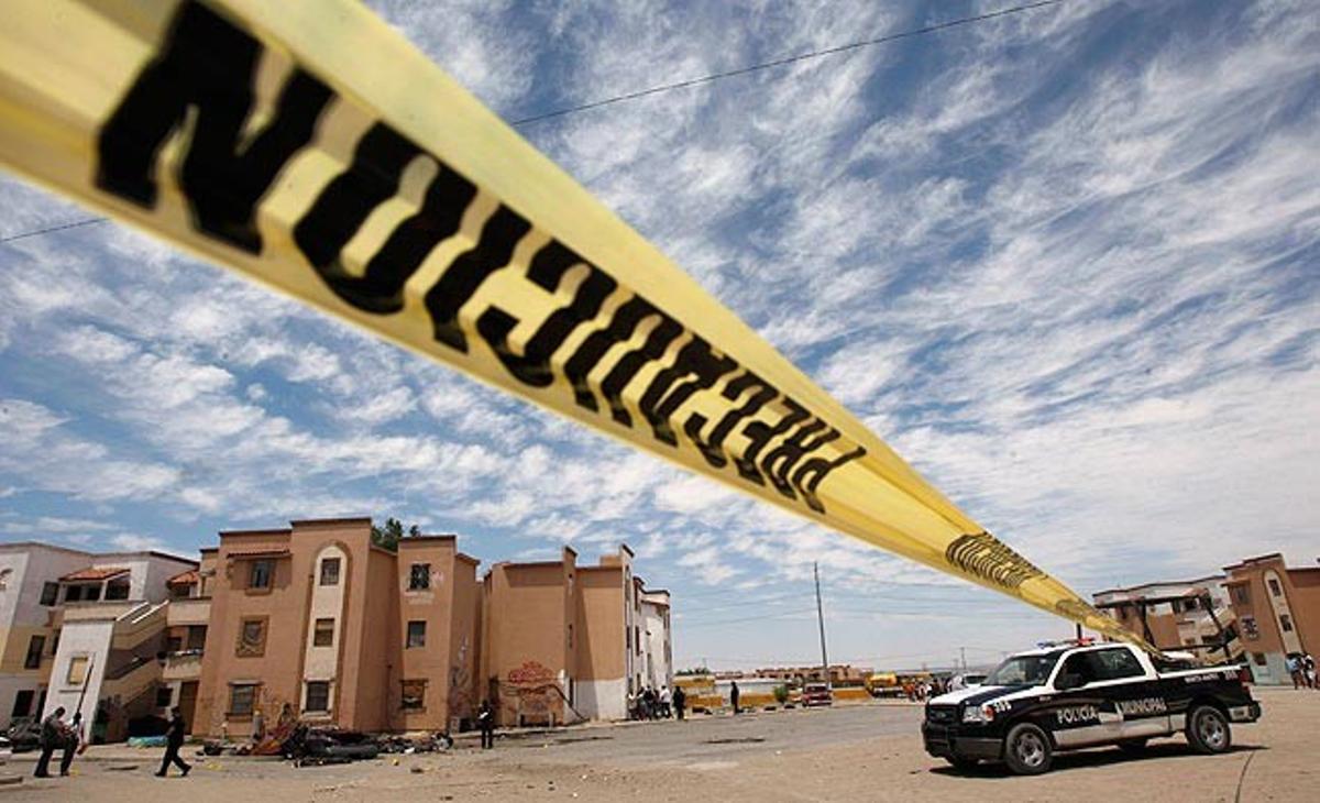 Un precinte policial envolta el lloc de Ciudad Juárez (Mèxic) on tres homes han estat assassinats aquest diumenge.