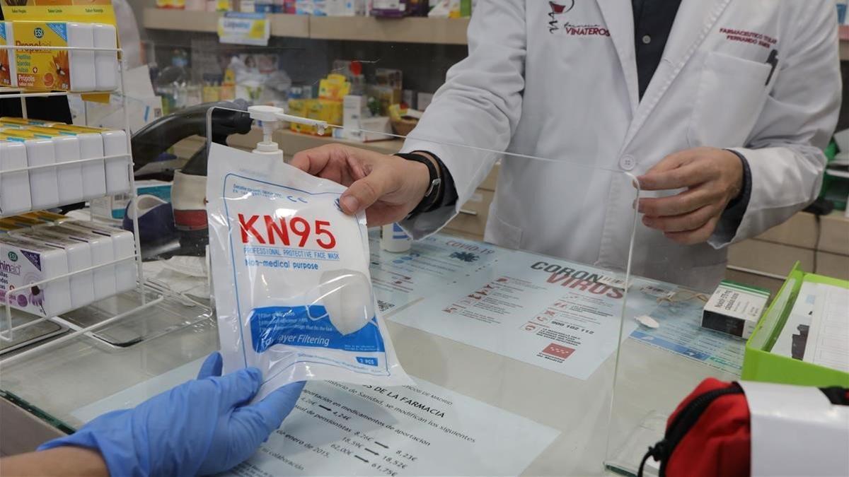 Un farmacéutico vende una mascarilla en Madrid, el 20 de abril del 2020