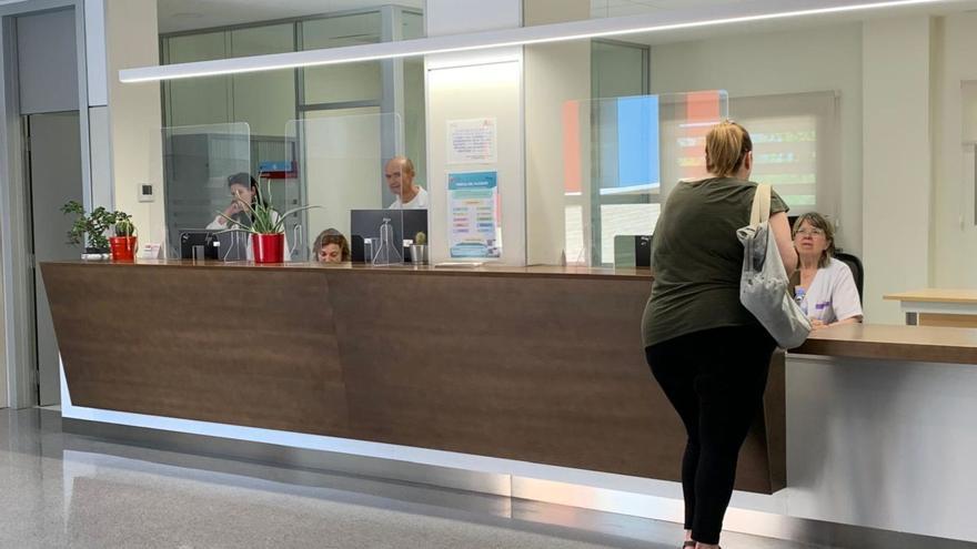 Una usuaria realiza una consulta a la administrativa en su centro de salud, en Murcia.