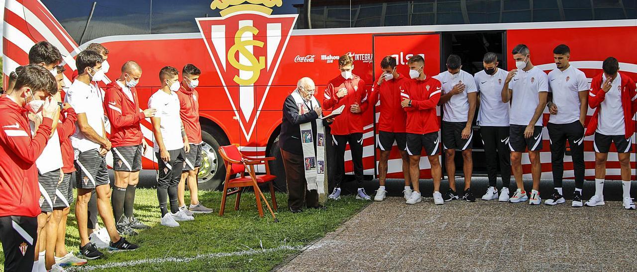 Por la izquierda, Guille Rosas, Pablo Pérez, Aitor, Valiente, Christian Rivera, Kravets, Berto, Gaspar, Fernando Fueyo, Gragera, Pedro Díaz, Bogdan, Mariño, Cuéllar, Borja López, Berrocal y Nacho Méndez se santiguan durante la oración para bendecir el nuevo autocar del Sporting. | Marcos León