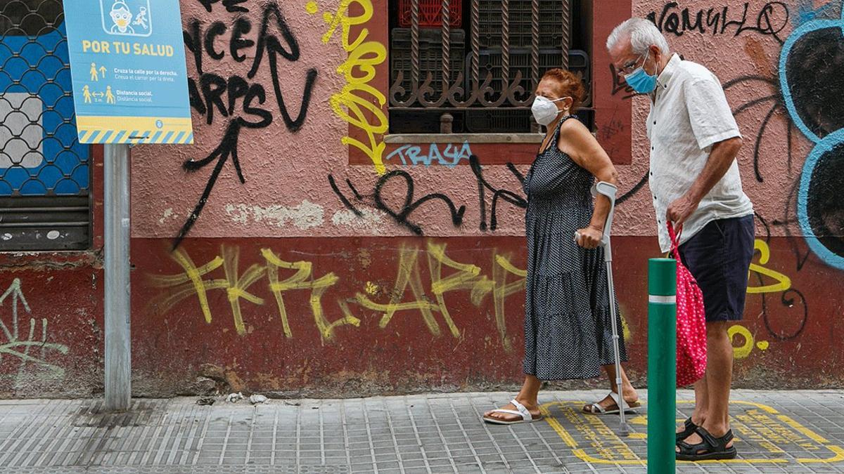 Una pareja de la tercera edad pasea por el barrio de la Torrassa, en L'Hospitalet, este domingo