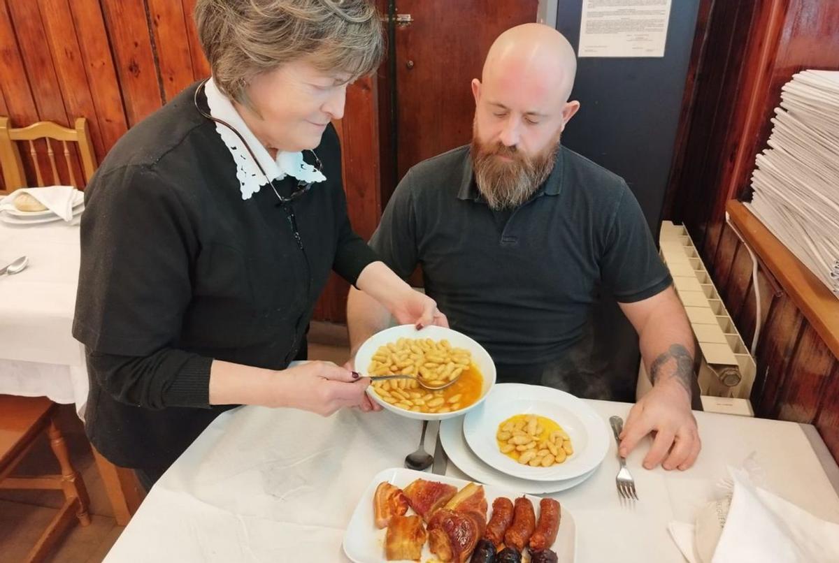 Luisa Vallina sirve fabada a Mario Cienfuegos en  La Felguera. | D. O.