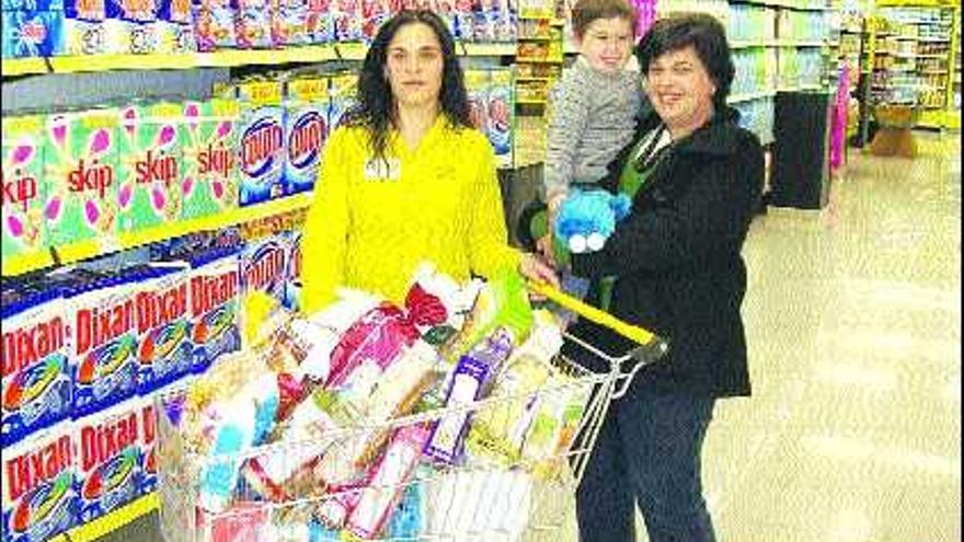 Reyes Méndez Méndez, de Andés (Navia), ganadora del cheque de compra por importe de cien euros, con su hijo Alejandro y la encargada del supermercado Aroa Fernández.