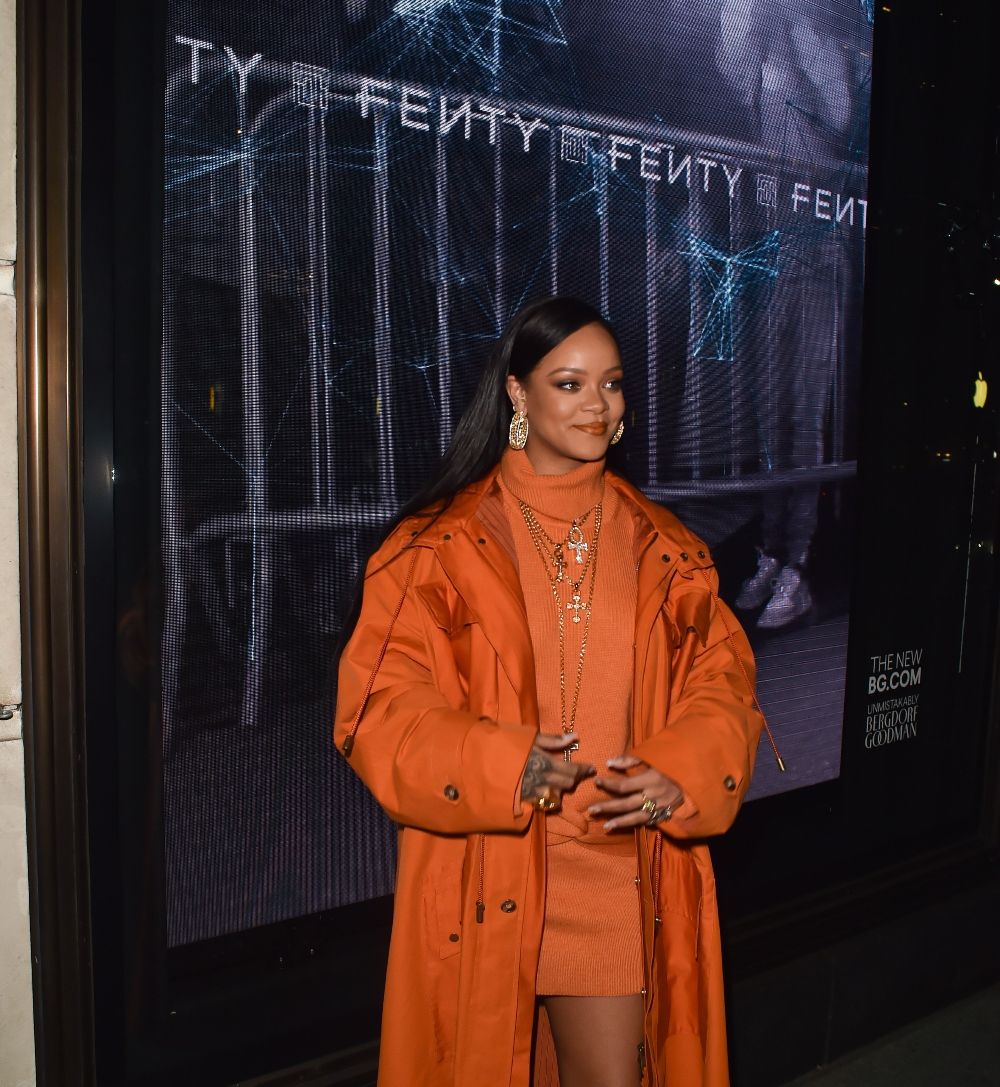 Rihanna con look en naranja en una tienda pop up de Fenty