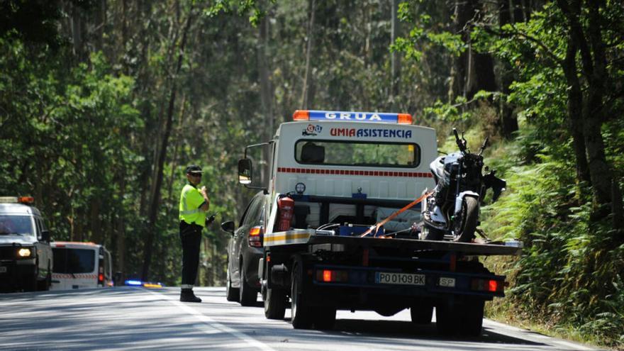 Una grúa retira la moto accidentada. // I. Abella