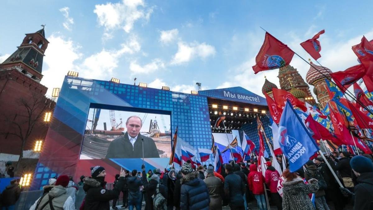 La multitud reunida en la plaza Roja de Moscú sigue el discurso de Putin retransmitido desde Crimea, este viernes.