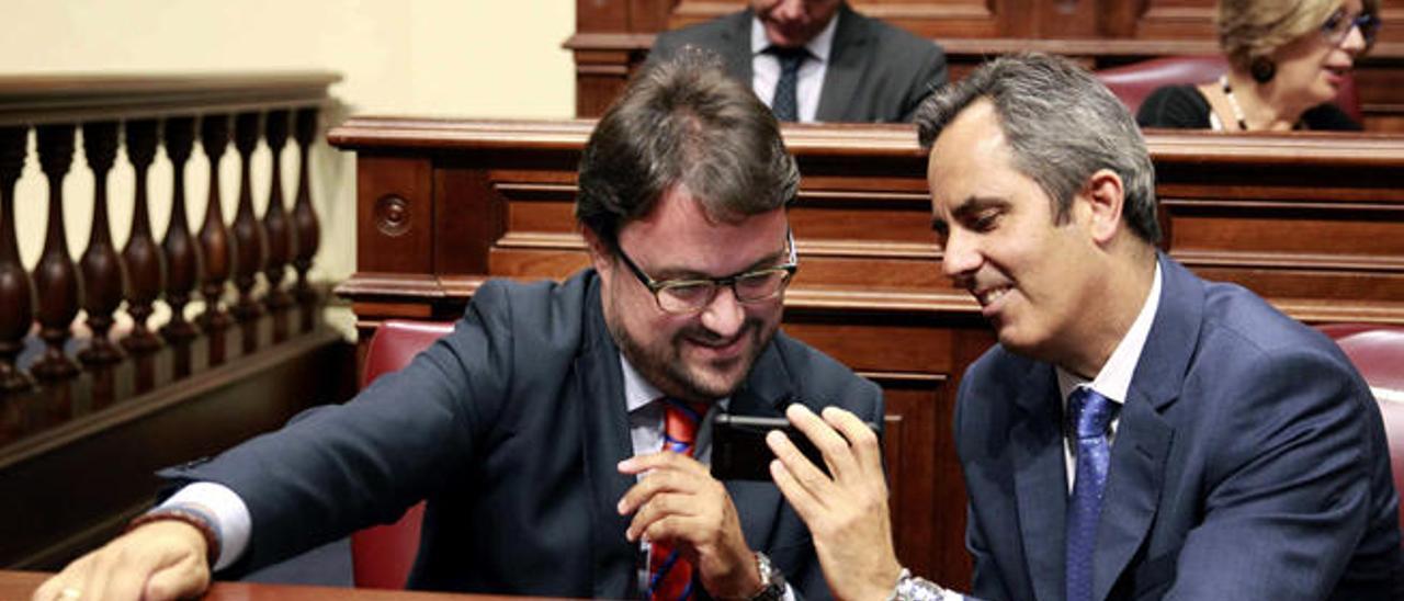 El secretario general del PP, Asier Antona, charla con el diputado Miguel Jorge Blanco antes del pleno del Parlamento.