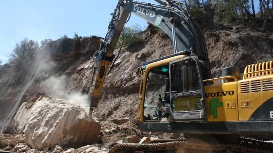 Màquina piconadora esmicolant una de les roques que van caure a la carretera, ahir al migdia