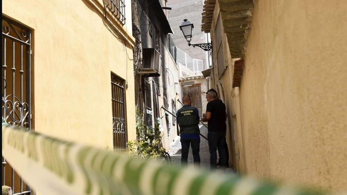 La Guardia Civil, en el callejón al que da uno de los accesos de la vivienda incendiada en Ricote, momentos después del suceso.