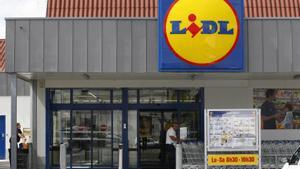 A customer takes a caddy outside a Lidl store in Saint Sebastien-sur-Loire near Nantes