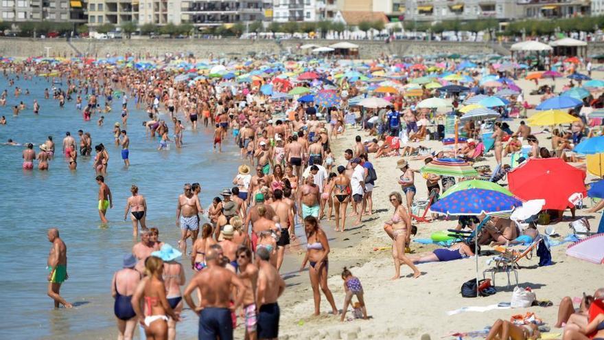 Turistas en la playa de Silgar, en Sanxenxo este verano. // G. S.
